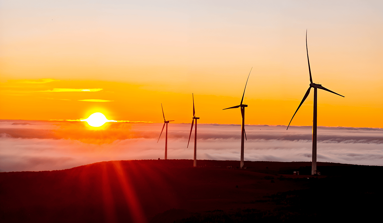 Molinos e&oacute;licos con puesta de sol